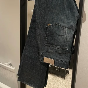 Lågmidjade jeans - Supersnygga lågmidjade bootcut jeans från Hugo boss i strl 26/32 (S) som tyvärr har blivit försmå. Väldigt bra skick 😇