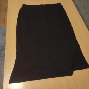 Kjol - Svart kjol från Lindex i storlek M. Lite öppet nedtill på kjolen på sidorna (se bild 2). 