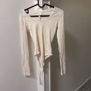 Vit Body från H&M  - Från H&M. Lite seethrough så man vet om det. Nypris. 150kr. Använd EN GÅNG. Passar även en M. Priset kan diskuteras. Hör av er ifall ni vill ha foton på hur den sitter! 