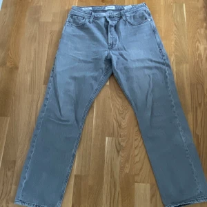 Gråa jeans - Gråa jeans från j&j. Strl 33/32. Är i använt skick. Sytt in dem lite i midjan, så en 32/32 får nog plats i dessa. 