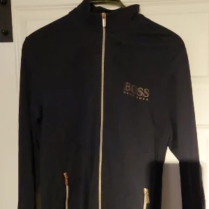 Hugo boss zip up - Säljer nu denna hugo boss zip up. Storlek L slimfit så passar L o M. Bra skick, inga skador eller fläckar enda defekten är att ena dragkedjan har tapöat lite färg och tricket på bröstet saknar några prickar men det är inget som syns vid användning.