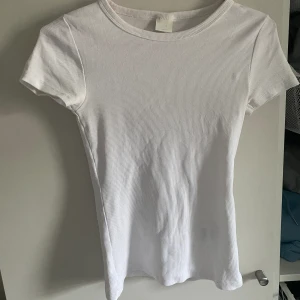 T-shirt - Vit tajt t-shirt. Katt finns i hemmet. 