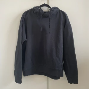 Svart hoodie  - • Syns att den är använd  • Lite urtvättad  