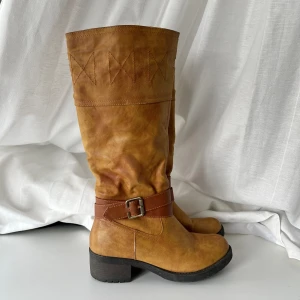 Stövlar - Vintage otroligt snygga stövlar med spänne. Använda men fortfarande i mycket bra skick 💕 Klackhöjden: 5 cm. Totalt höjd (från häl): 40 cm. Fotsula: ca 25 cm. Storlek 37, passar 38 också 