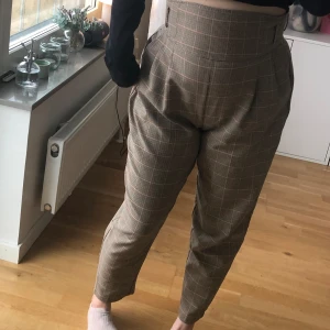 Högmidjade rutiga kostymbyxor  - Högmidjade kostymbyxor med dragkedja i bak! 