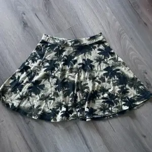 Mini kjol från Gina med Palm mönster. Den är i strl xs men stretchig i midjan. Använd fåtal gånger och inga defekter finns.