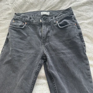 Gina Tricot Lågmidjad Jeans 🖤🩶 - I mörkgrå färg och Lågmidjad🩶 använd under en säsong och är helt defekt fri. Passar mig som är 172 men rekommenderar för er som är ca 165 för bättre passform ❤️. Storlek 34/xs. Min midja: 63. Köpte den för 450kr.
