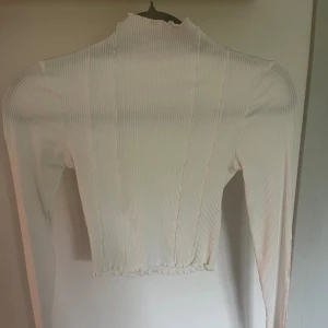 Vit långarmad tröja - Vit långarmad tröja med detaljer. Använd en gång men kommer inte till användning så i nyskick. Ser genomskinlig ut på bilden men är inte i verkligheten. Vid fler frågor eller bilder är det bara att kontakta i chatten. Köparen står för frakten💕