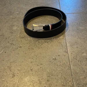 Tommy Hilfiger läder bälte - Säljer detta snygga Tommy Hilfiger läder bälte. Det kostar igentligen 700kr men jag säljer för 300kr. Det är jättebra skick och självklart äkta, kontakta om du är intresserad.