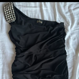 Svart one shoulder  - Svart linne med gråa spikar på axeln, Väldigt bra skick använd några gånger. Säljer då den tyvärr inte är min stil