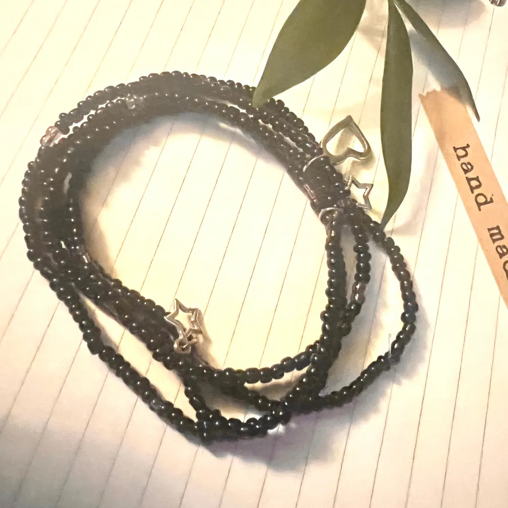 Armband i 4-rader med svarta och lila pärlor med silver detaljer . Accessoarer.