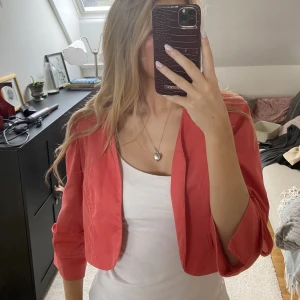 Korall färgad bolero - En korallfärgad bolero med trekvarts armar