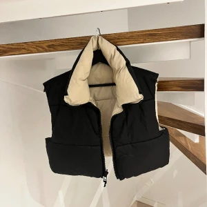 Zara cropped puffar vest  - Denna söta croppade puffar västen är köpt ifrån Zara i strl S. Kan bytas till både beige och svart färg. För söt men aldrig använd. Skicka meddelande vid intresse/ fler bilder🤍