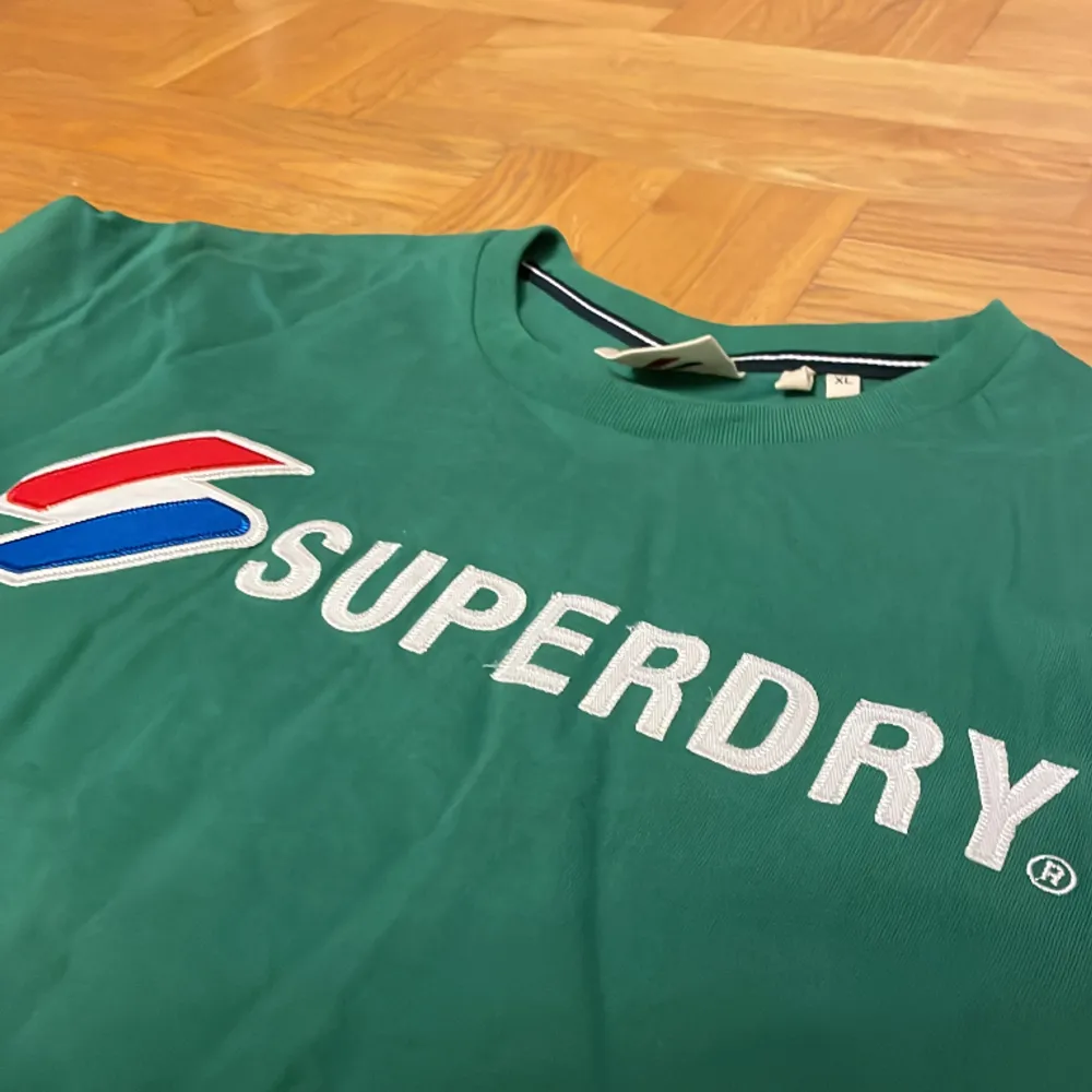 En T-shirt från Superdry som inte är använd många gånger så den är i bra tillstånd. Den är lite mer grön i verkligheten än på bild . T-shirts.