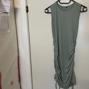 Ljus grön klänning  - Ljus grön klänning perfekt till sommaren  går att justera längden på sidan med hjälp av snören  fint skick  Storlek 38/m