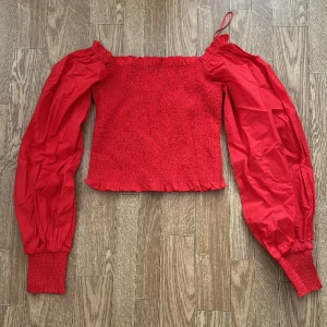 Röd topp  - Storlek M, från Gina Tricot. Använd en gång. Man kan ha den off shoulder eller vanligt så det blir puffigt om axlarna. 200kr + frakt, annars hämtas det i Eskilstuna 