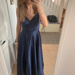 Marinblå balklänning från JJ’s house - Köpt hel ny och är i jättefint skick, använd endast en gång och är inte uppsydd. Är 168cm och går ner till marken när jag hade 5cm klackar. Justerbar i ryggen då det är en korsett. Slits vid benet. Inbyggda ilägg💕köparen står för frakten🙌🏼