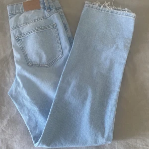 Low waist jeans - Ljusblå low waist straight jeans low från Gina Young. Storlek 164, skulle säga att de passar 32/34. Innerbenslängden är 76 cm. Slitningar och reglerbar midja. Färgen stämmer på bild 3! Oanvända med lappen kvar. Slutsåld på hemsida. Köparen betalar frakten!