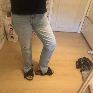 Jeans - Jeans med slits längst ner och två slitningar på vänster ben. Använda cirka 5 gånger, inga skador.