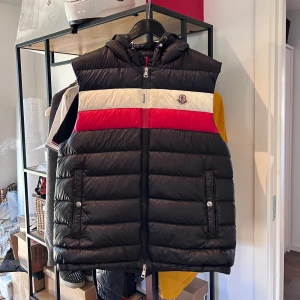 Moncler Timothe väst - Moncler Timothe väst i bra skick, flaw på bröstet som syns på bild 3 liten reva annars nyskick. Storlek 5 passar en L, nypris 8000 mitt pris 2000! Över 70 nöjda kundrecensioner finns, bara att skriva vid frågor eller funderingar!