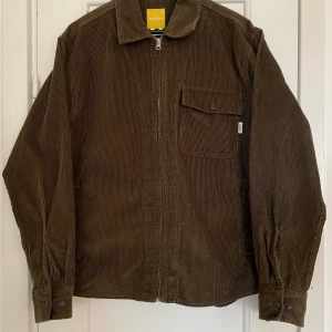 Overshirt i manchester från Rotation (Carlings) - Mörkgrön/Militärgrön overshirt i manchester från Carlings märke Rotation. Stl S(herr), rak och lite lösare passform Dragkedja hela vägen samt två fickor i sidan och en bröstficka. Endast använd 1 gång och är i nyskick