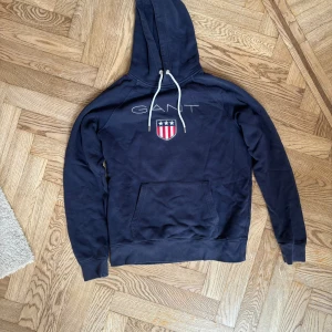 GANT Hoodie Marinblå - Tjena! Säljer nu denna mörkblåa Gant Hoodie i storlek L. Den är i nyskick. Har du funderingar eller är i behov utav ytterligare bilder, tveka inte att höra av dig!