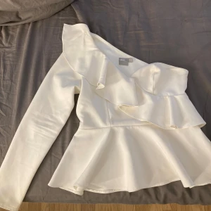 One shouldet volang topp - Säljer denna sjukt fina topp köpt på plick då den tyvärr är för liten för mig. Priset gåt att diskurera. Skriv för bilder med den på