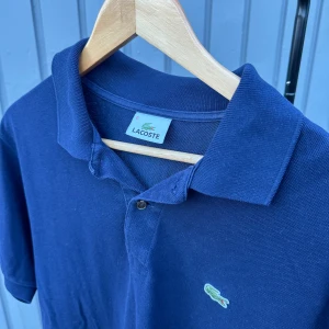Lacoste piké - Fin Lacoste piké som knappt använts! Skick 9/10, riktigt fräsch t sommaren. Säljes pga att den e för stor för mig.