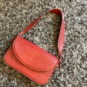 Röd väska  - Röd/brun väska från Mango. Den är använd fåtal gånger men det syns inte på skicket. Den är rymlig och töjbar och får därför plats med mycket. 