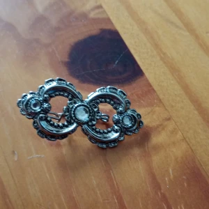 Brosch mönstrad silverfärgade. - Brosch mönstrad silverfärgade.