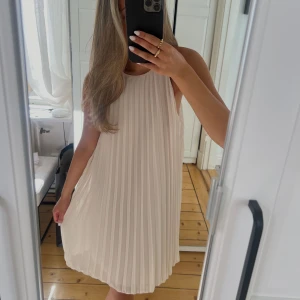 Plisserad klänning - Knälång plisserad klänning i smutsrosa färg. Helt oanvänd med prislapp kvar. Köptes för 299kr🤍🤍