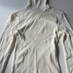  Vit polotröja  - Vit stickad tröja med hög hals. Tröjan är i ribbstickning och har storlek s. Har endast använt några få gånger.