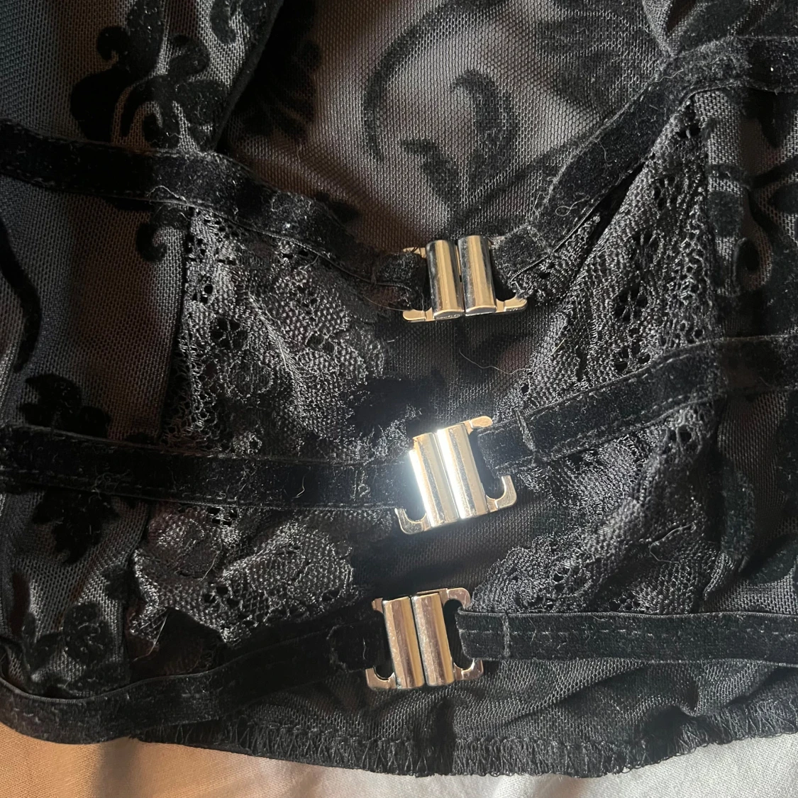 Svart blus med spetsdetaljer och spännen - 90