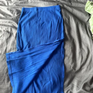 Blå ribbad kjol - En blå ribbad kjol i lång modell. Kjolen har en enkel och stilren design utan synliga detaljer. Slits.