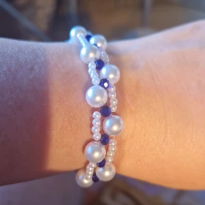 Pärlarmband  - Egen design  Vita pärlor med marinblå gnistrande mellanpärlor. Förlängningskedja