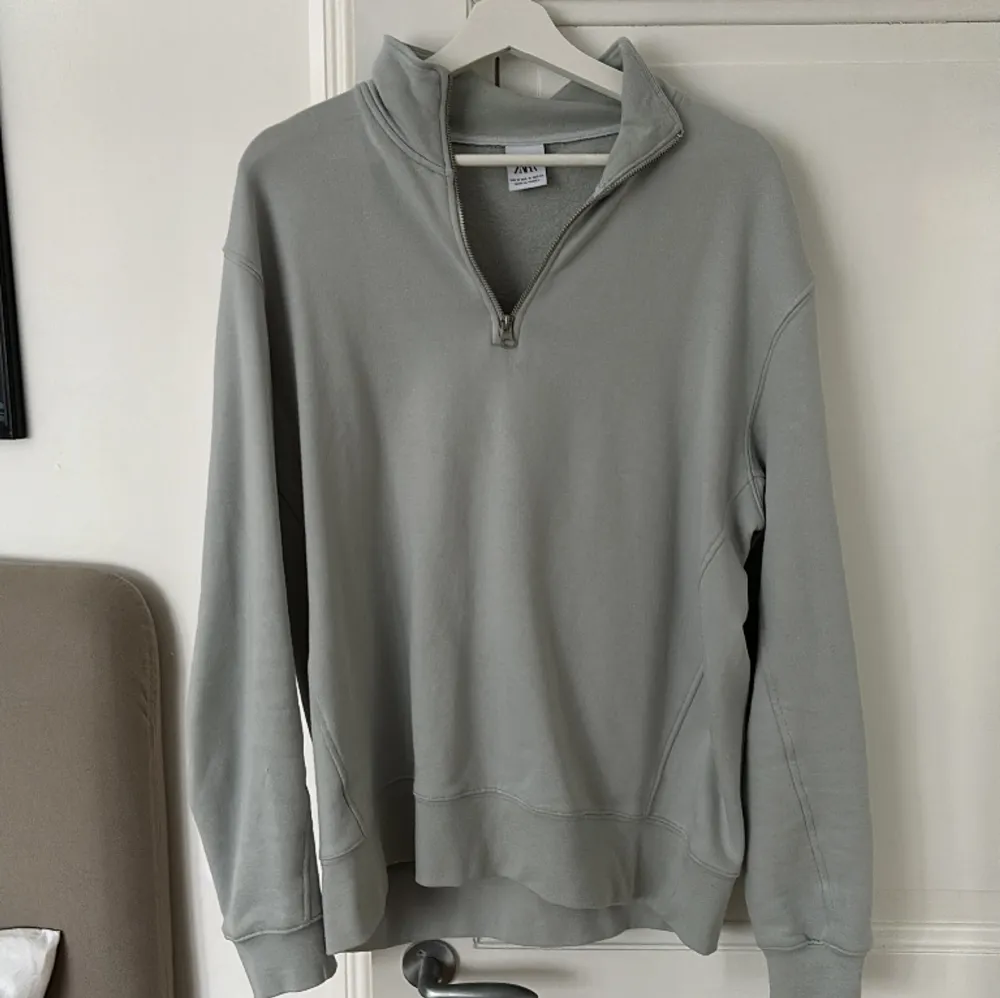 En ljusgrå 1/4 tröja från Zara i nyskick, använd ca 2 gånger och den är i storlek M. Tröjor & Koftor.