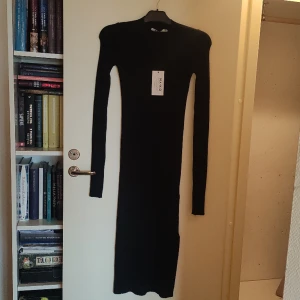 Ribbstickad klänning från NA-KD - Oanvänd, ribbstickad klänning från NA-KD. Jättefin, men tyvärr lite för lång för mig. Fin passform, slits på höger sida, varm och skön! Kan mötas upp i lund, annars står köparen för frakten 🌸
