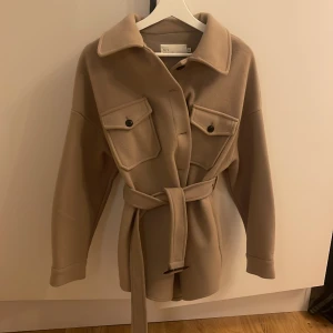 Kort kappa från Nelly - Säljer kortare kappa från Nelly då den inte passar längre! Storlek 32 men lite oversize i modellen! 