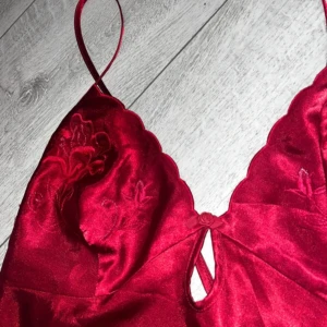 Satin linne - Säljer detta linnet i satin, med såå fina detaljer tex en dekorativ ros i mitten och vackert broderi på bysten☺️