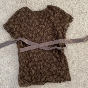 Supersöt 2000s topp med spets och knyte  - Så söt tröja men band under bysten så man kan få passformen mer tight. Går att knyta både fram och bak beroende på vad man tycker är snyggast. Står strl L men eftersom den kan knytas passar den fint på S också. Inga defekter även fast den är vintage!