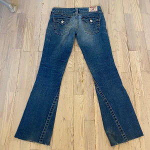 True religion jeans - Innerbenslängd: 76cm (jag är 162cm) Midjemått: 38-39cm Lågmidjade bootcut true religion jeans som är avklippta vid benen men det ser inte konstigt ut. På rumpan så är de även lagade med sömmar och därav priset. Kom privat för bild på lagningen. 