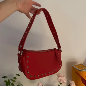 250 - Röd läderväska med nitar 