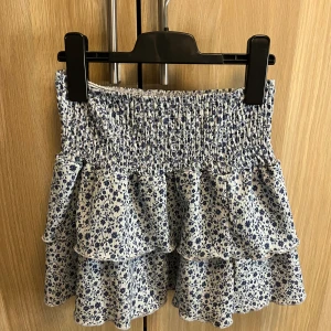 Blommig kjol - Jätte fin blå blommig kjol från ginatricot. Kjolen är i storlek 146-152 och väldigt töjbar så skulle säga att den passar dig om du har storlek xs. Använt ett fåtal gånger och i mycket fint skick❤️