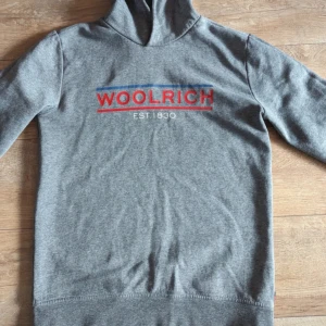 Woolrich Hoodie - Woolrich hoodie som passar S, kille i bild 177 cm sitter perfekt. Inget slitage. Nypris ungefär 2000 kr. KAN SKICKA BILD PÅ BLEV FEL NÄR ANNONSEN PUBLICERADES.