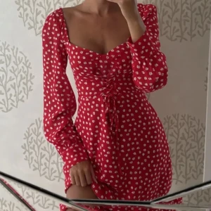 Adoore Klänning - Klänning från Adoore i modellen Mykonos Dress i en röd färg med vita blommor på. I superfint skick då den endast är använd några fåtal gånger. Nypris: 1195kr. Mitt pris går att diskutera! (Första 2 bilderna lånade från Instagram).