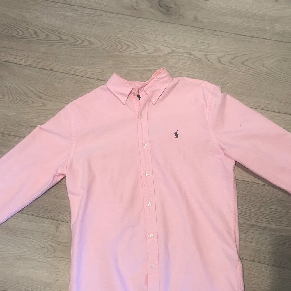 Säljer denna rosa och stilrena skjorta ifrån Ralph Lauren eftersom den inte passar. Skicket är vänligt bra då den inte har kommit till så mycket användning. Storleken är M. Skjortor.