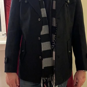 Jacka/Rock/Kappa - Snygg rock/kappa m. scarf säljes Strl; M  Färg; marinblå + grå/blå randig scarf  I nyskick aldrig använd 