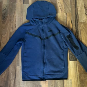 Nike tech Komplett Set Navy Blue - Storleken på denna fina träningset är 147-158. skick 7/10 finns i bild 3-5 lite slitage men det är inget som man märker. PRIS KAN DISKUTERAS, Tveka ej på att ställa frågor!