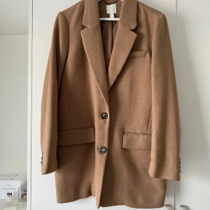 Kavaj från H&M studio  - Snygg kavaj från H&M studio. Storlek S men funkar som M likaså. Använd en gång och finns mindre fläckar vid ena armen som går bort vid tvätt. (Har ej tvättat den) 