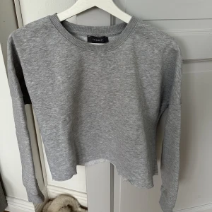 Croppad grå sweatshirt - Grå croppad sweatshirt i strl XS. Använd fåtal gånger.